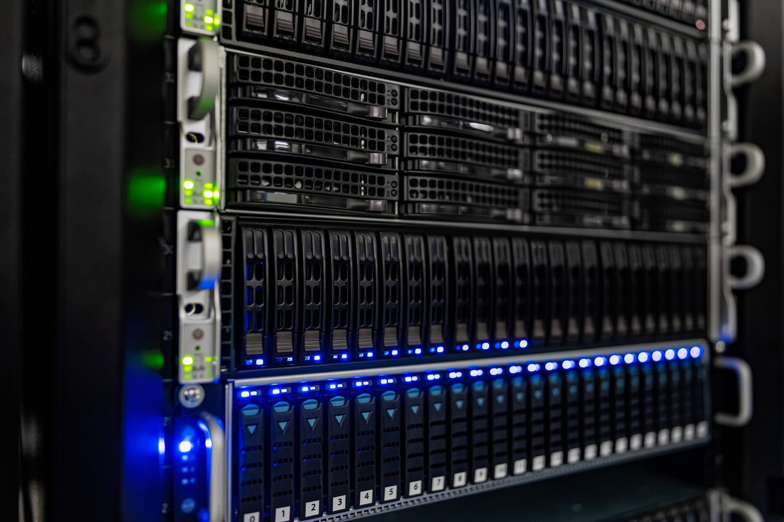 Rows of black server racks with blue network cables in a computer room.