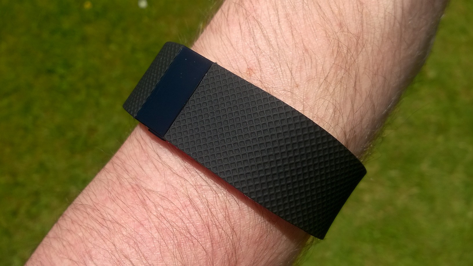 A black Fitbit Charge HR fitness tracker worn on a wrist.