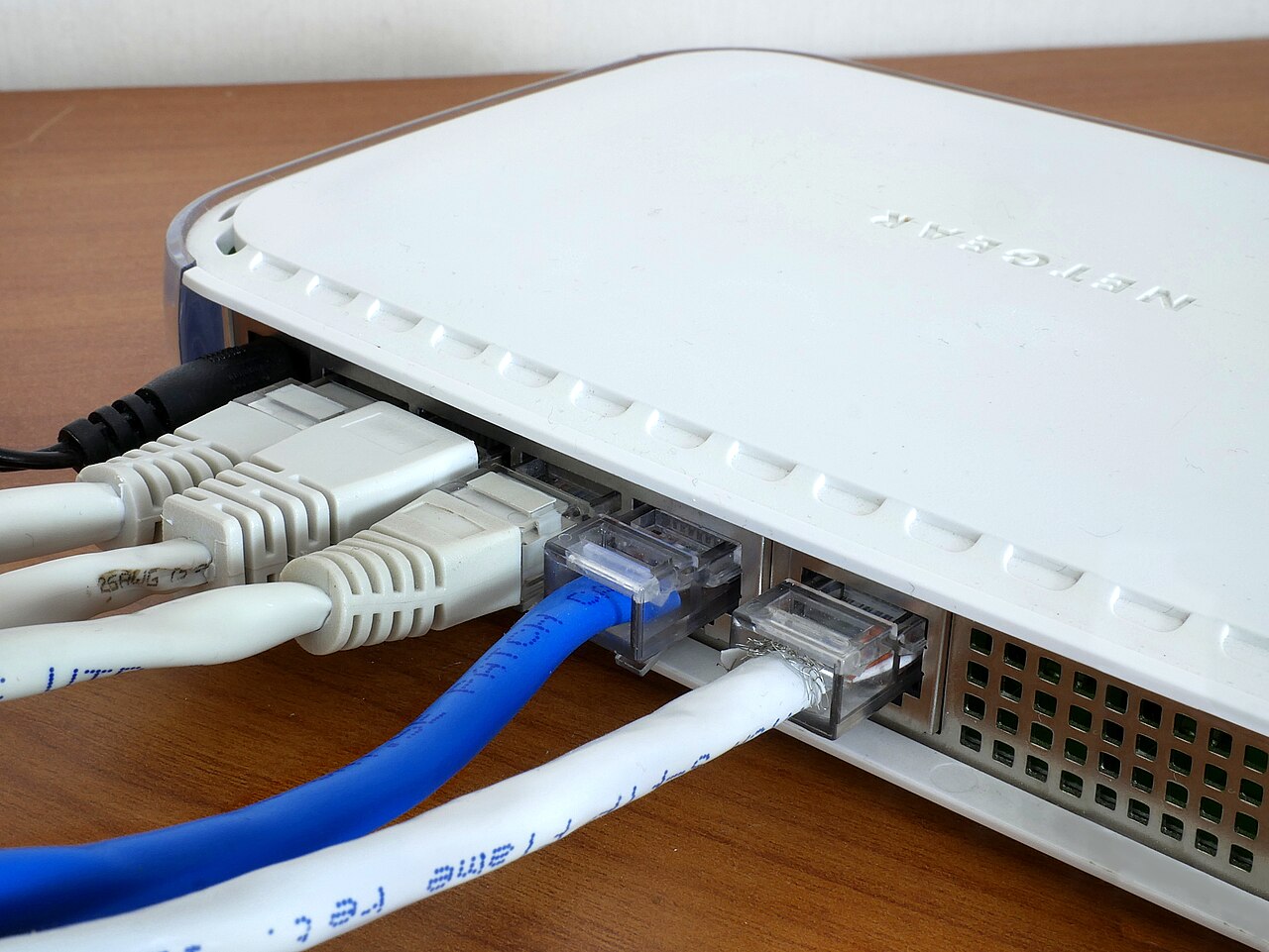 Yellow, blue, and gray ethernet cables plugged into a network switch.