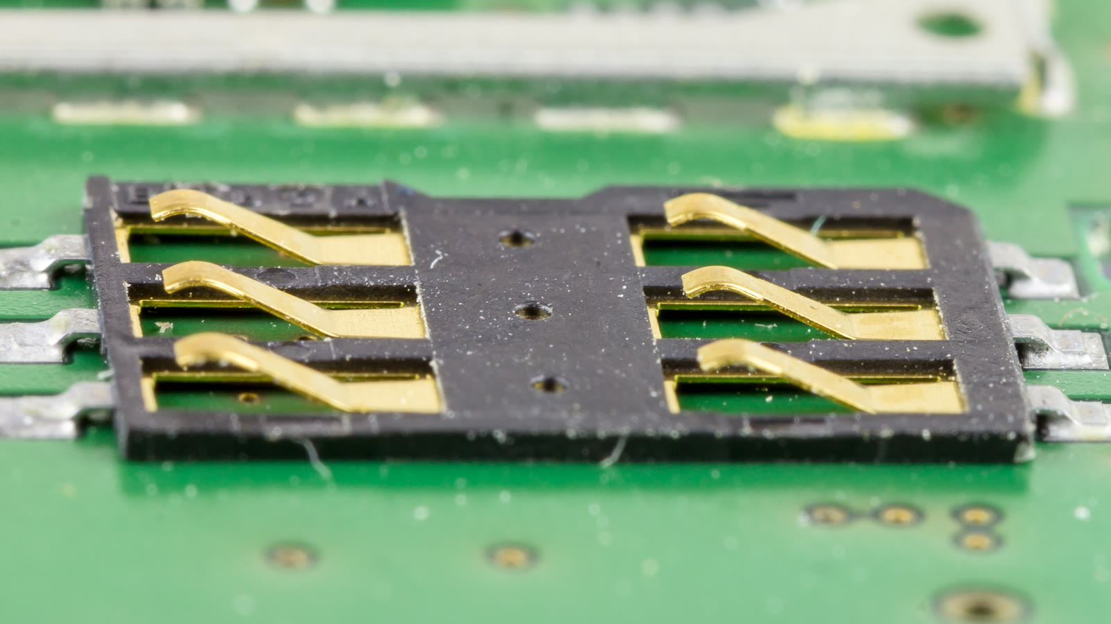Macro photograph of gold SIM-card contact springs inside a cellular modem card.