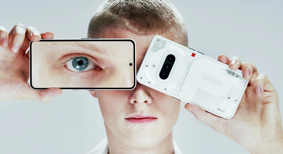 A person holds two white Nothing Phone (3a) handsets, showing the screen and transparent-style rear panel.
