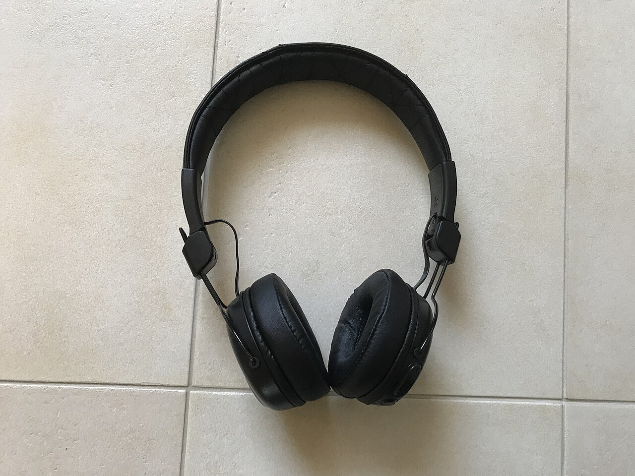 Black JLab headphones photographed on a light surface.