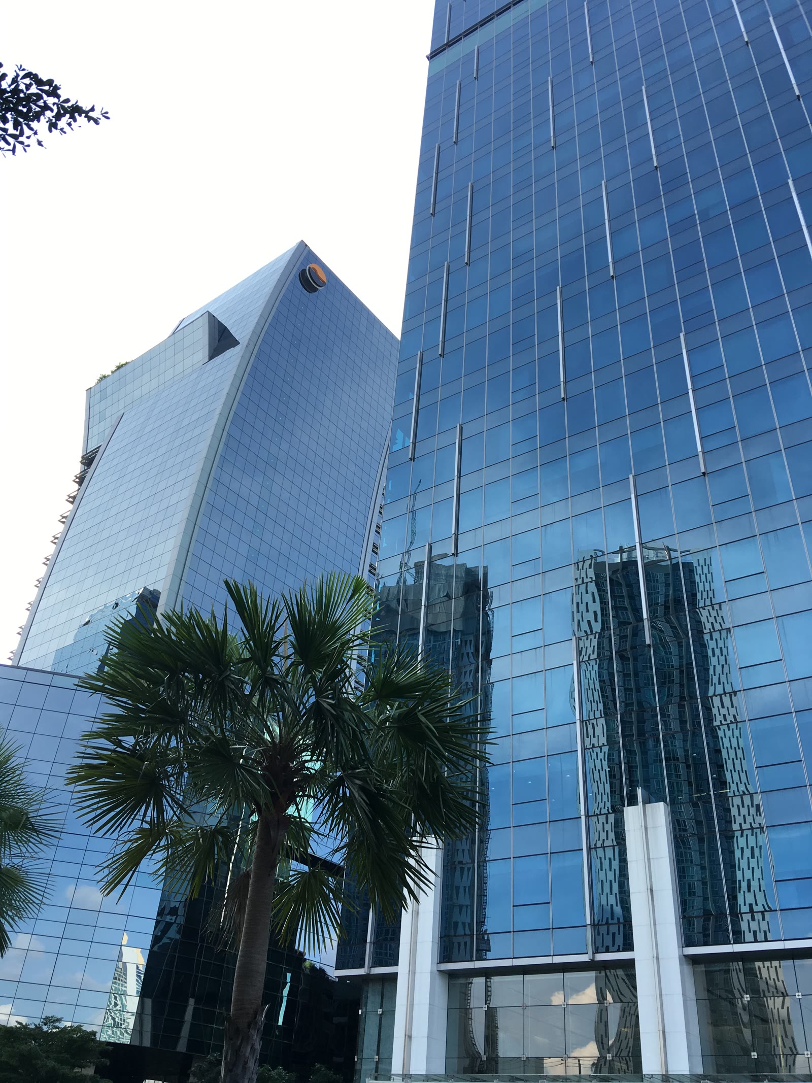 The Stock Exchange of Thailand building in Bangkok, with the AIA tower beside it and traffic in the foreground.