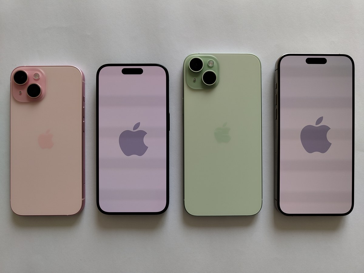Pink and green iPhone 15 models photographed from the front and back on a pale surface.