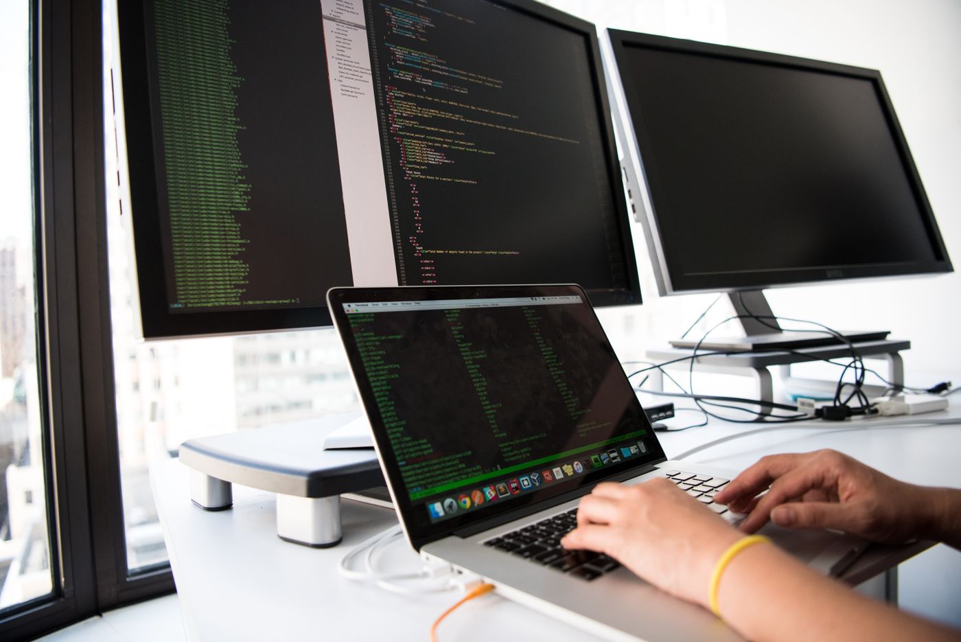 Developer working at a laptop with code visible on the screen