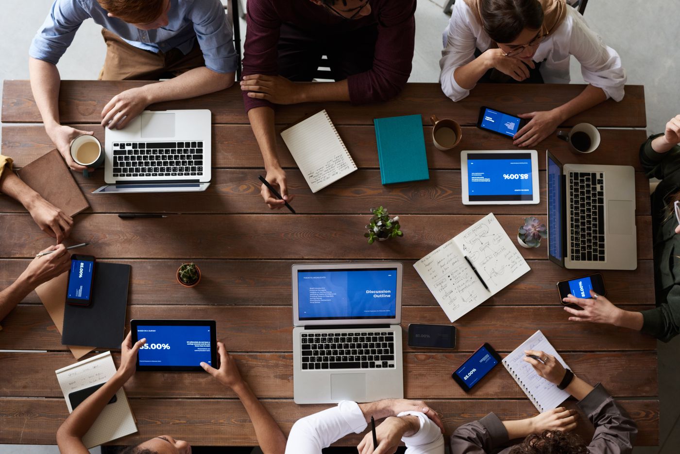 People in a conference room discussing documents around a table