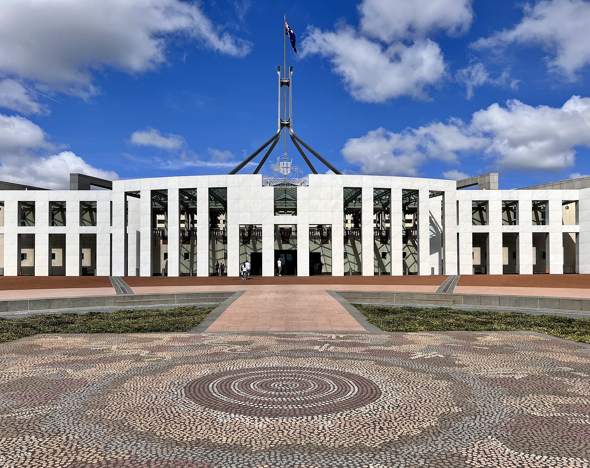 Parliament House in Canberra with the Australian flag flying above the forecourt mosaic