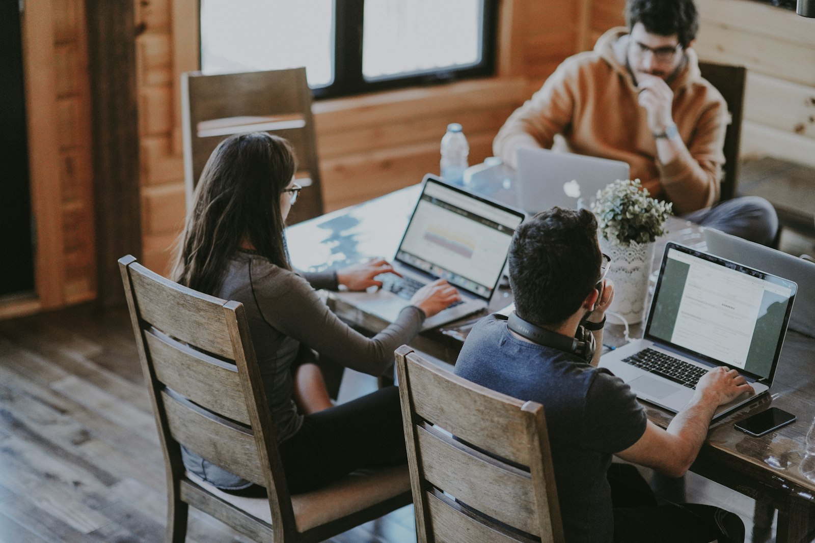 Diverse team smiling during a meeting at a wooden table