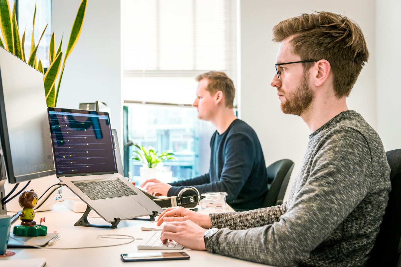 Colleagues discussing work over a laptop in an office
