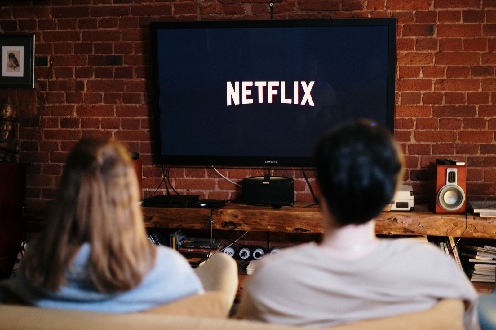 People watching a large television in a dark home theater room