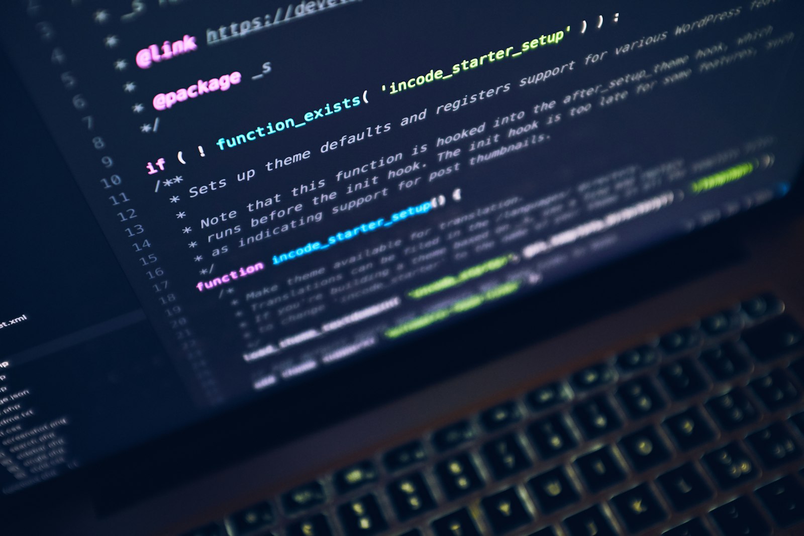 Laptop showing dark code editor on a wooden desk
