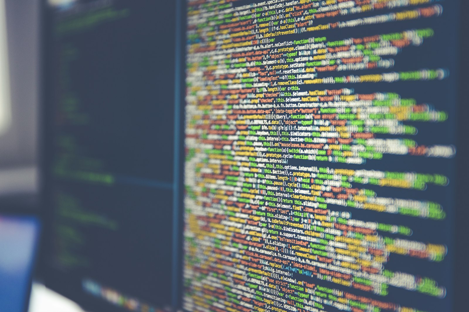 Laptop screen showing colorful lines of code in a dark editor