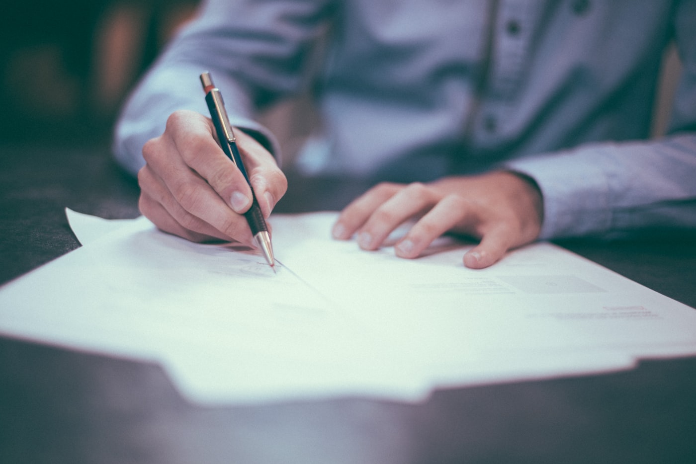 Business documents and pen on a wooden desk