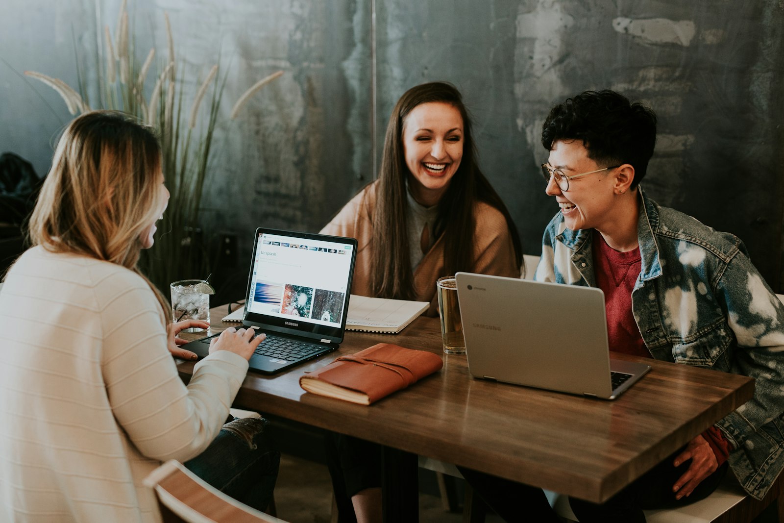 People collaborating around laptops at a shared table