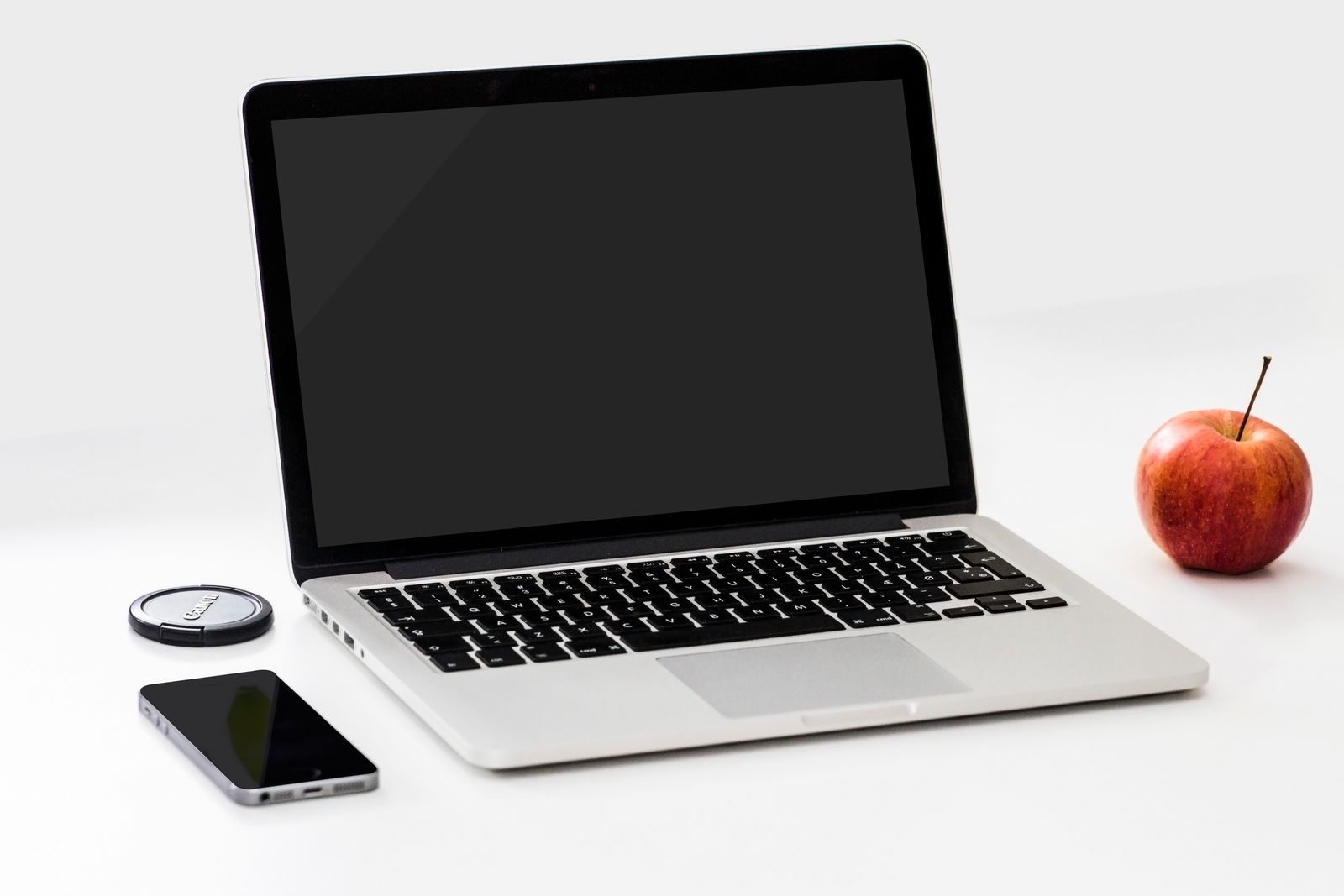 Open silver laptop on a wooden desk showing a bright screen