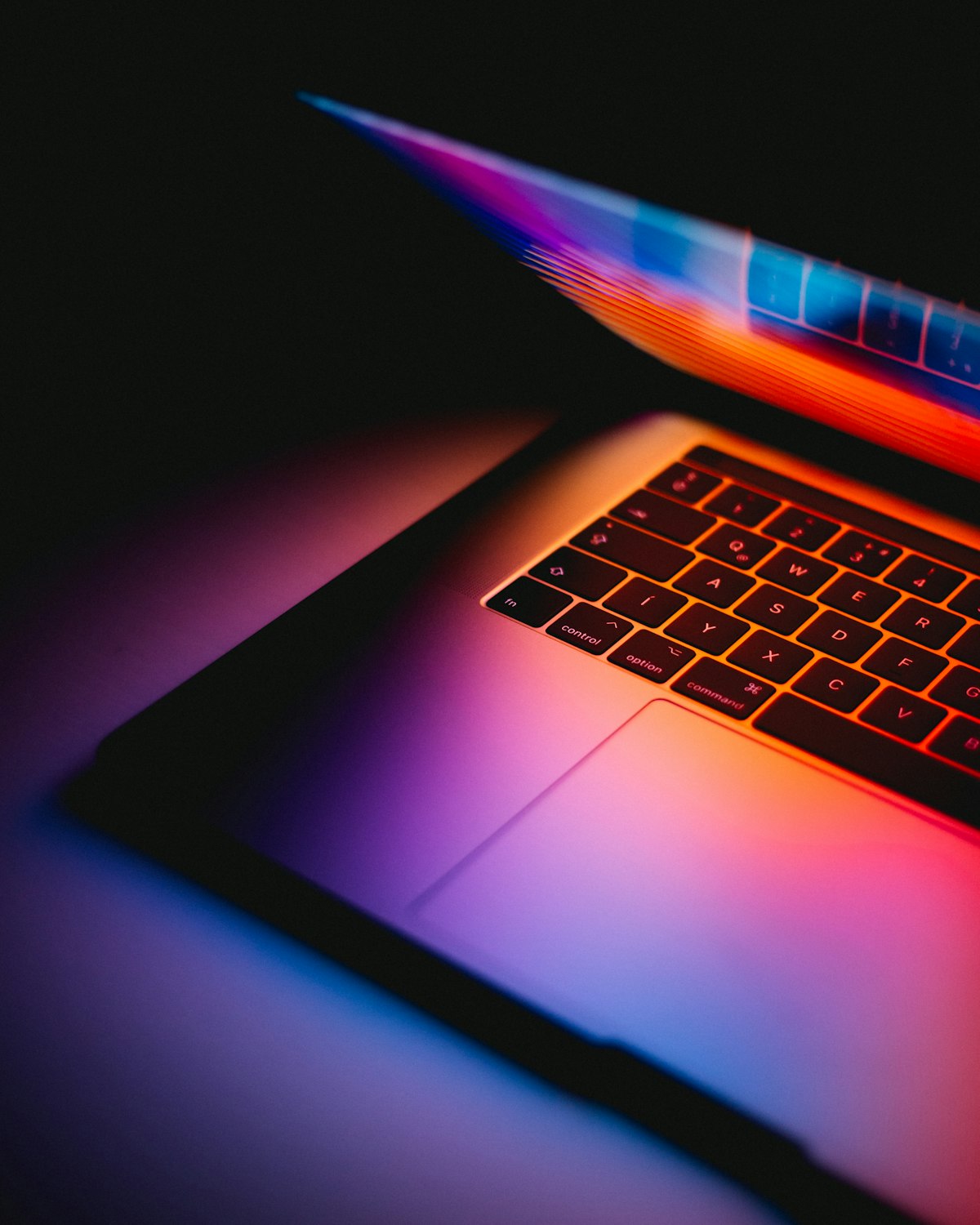 Open laptop on a wooden desk near a window