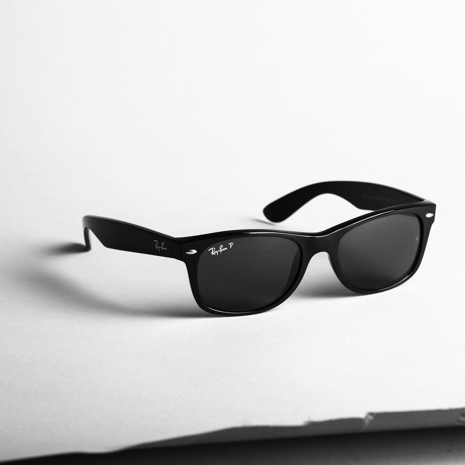 Black Ray-Ban Wayfarer sunglasses on a clean studio surface