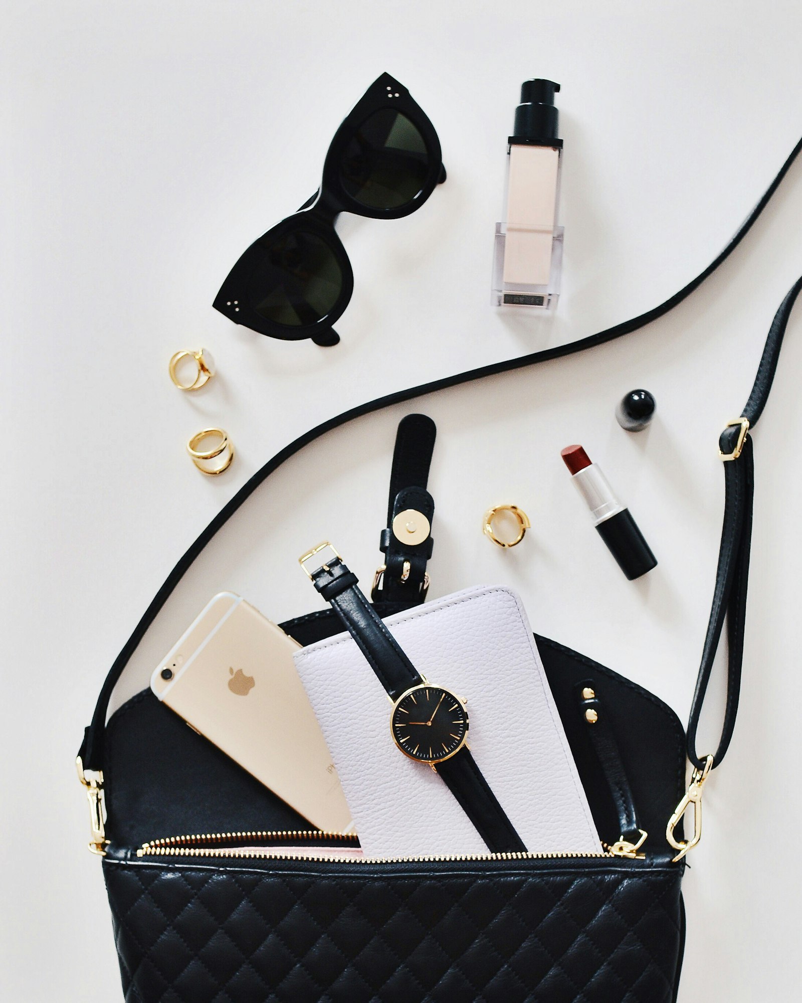 Fashion flatlay with cat-eye sunglasses, watch, and bag