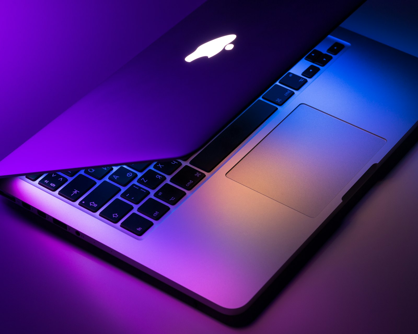 Silver MacBook laptop open on a wooden desk