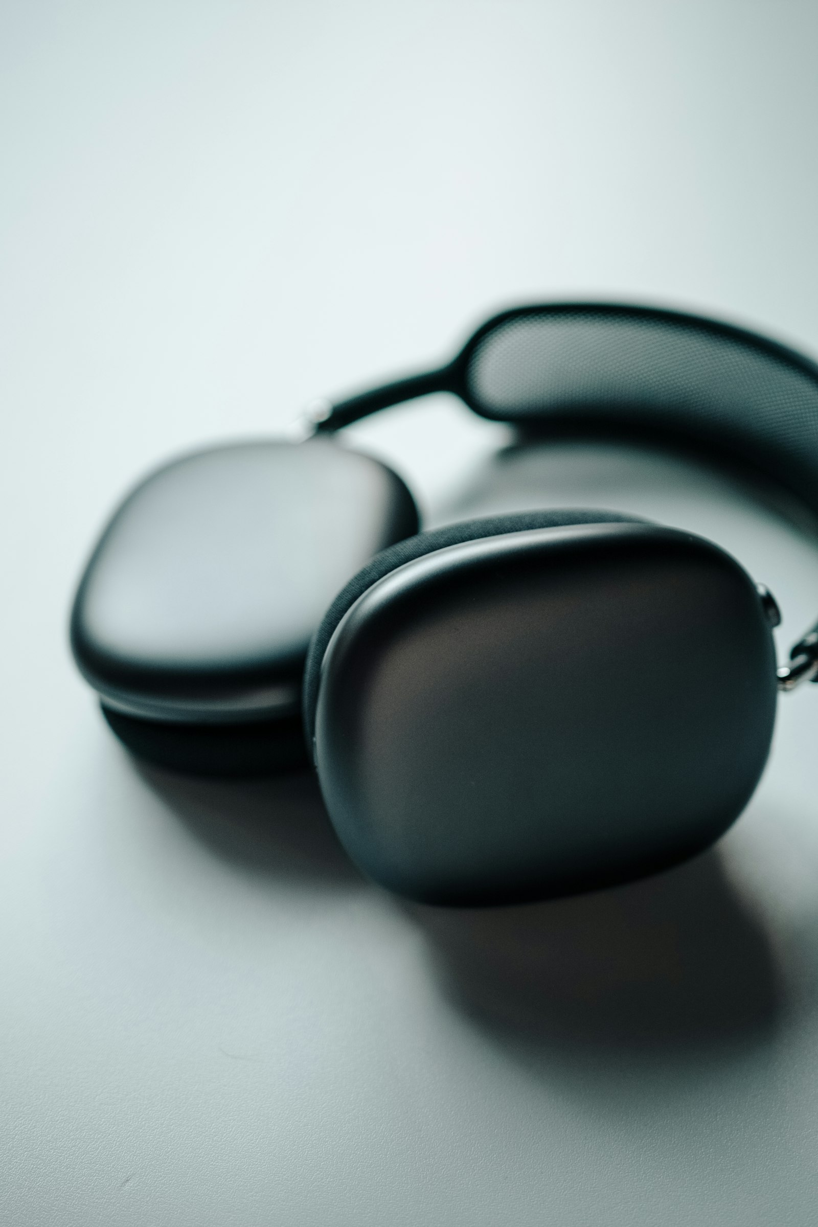 Black over-ear headphones resting on a light surface