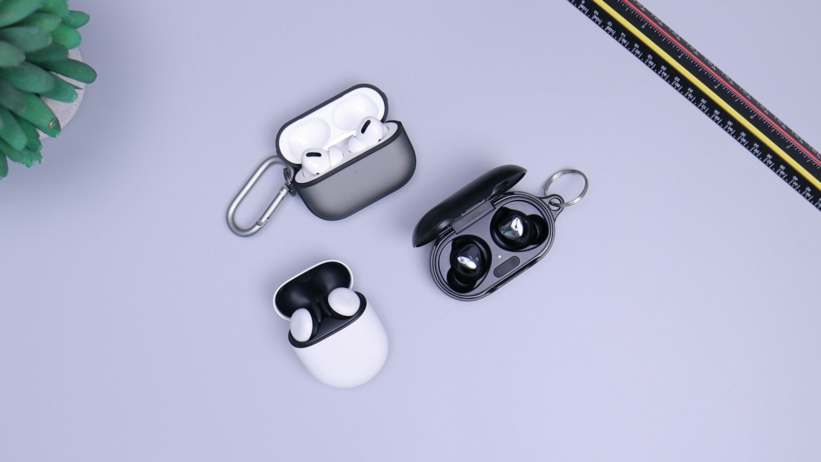 Pink wireless earbuds resting on a colorful surface