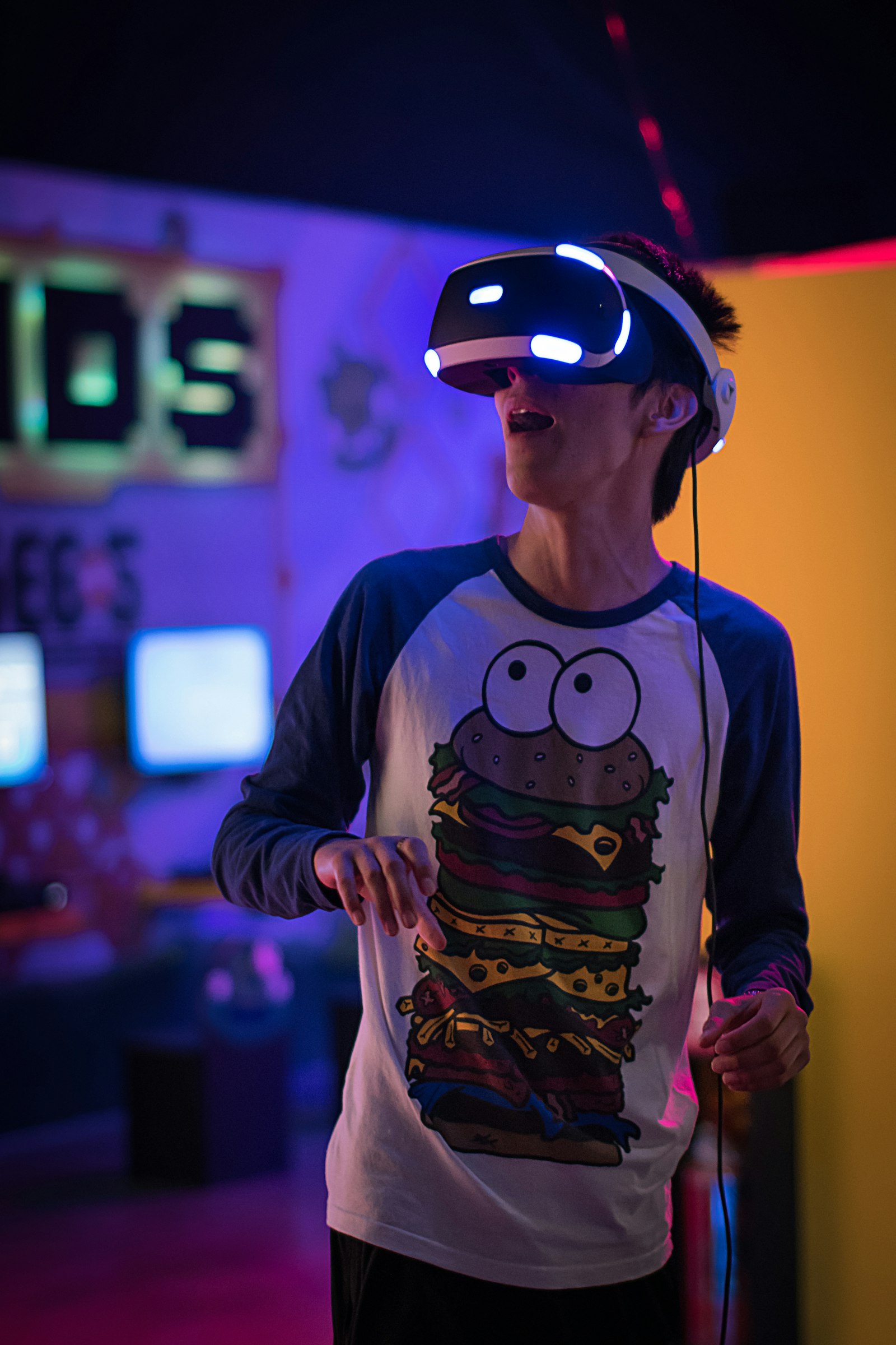 Person wearing a VR headset in a neon-lit entertainment space