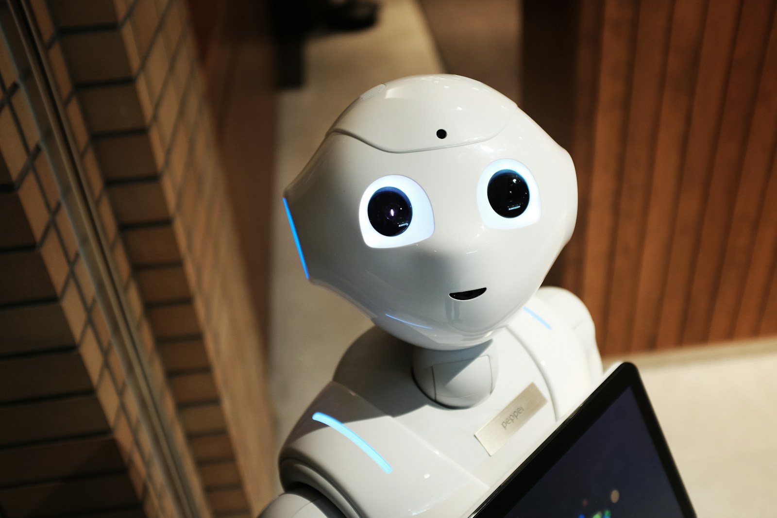 White robot hand reaching toward a laptop keyboard