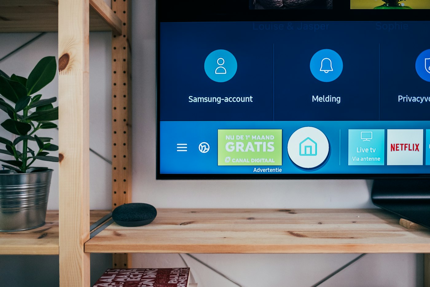 Samsung smart TV home screen showing Netflix and live TV icons above a wooden shelf