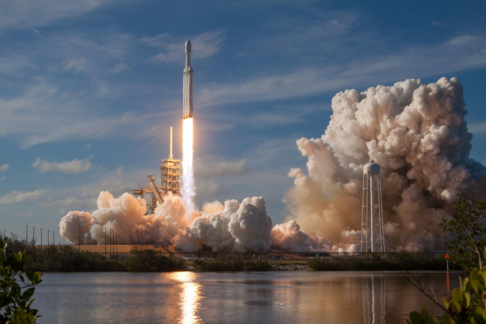 Rocket launching into a blue sky with smoke trail