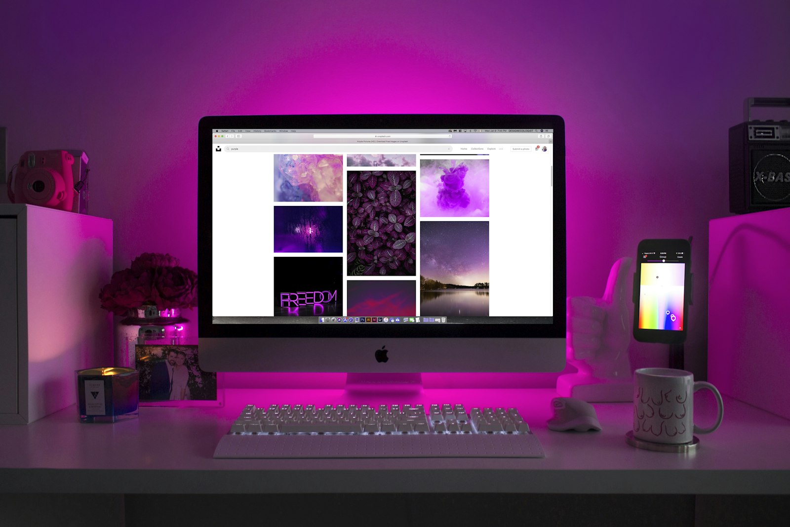Desktop setup with keyboard, mouse, and monitor under pink lighting