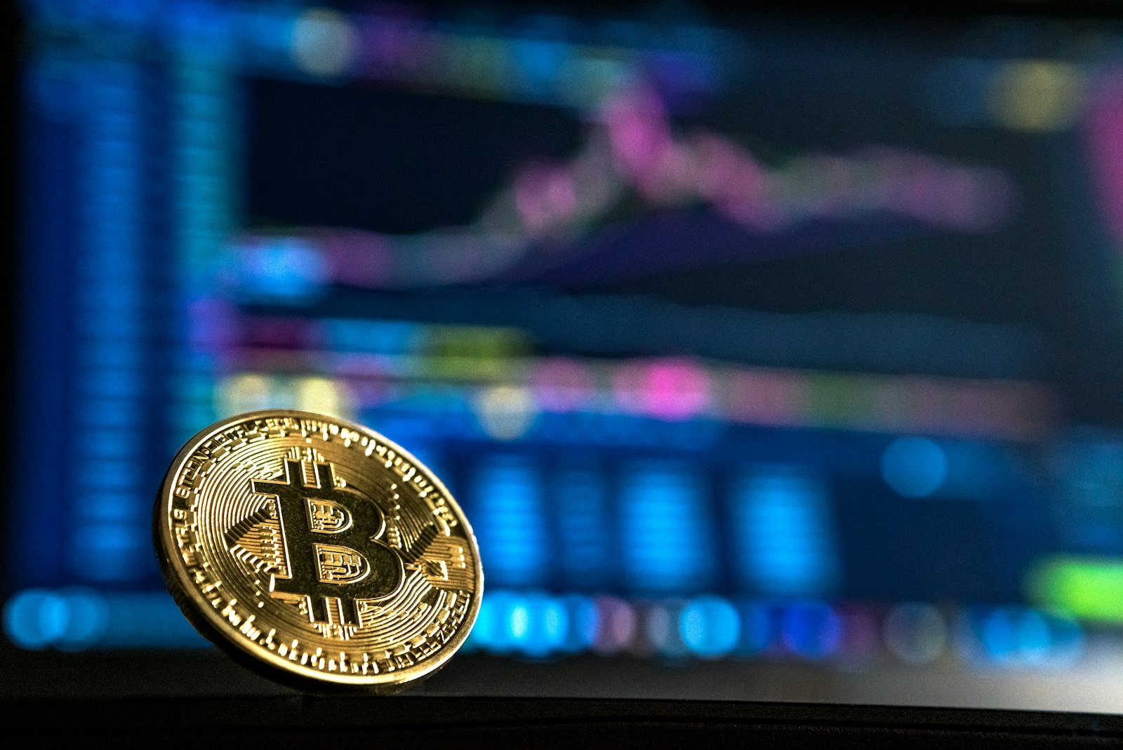 Physical bitcoin coin resting on a dark surface