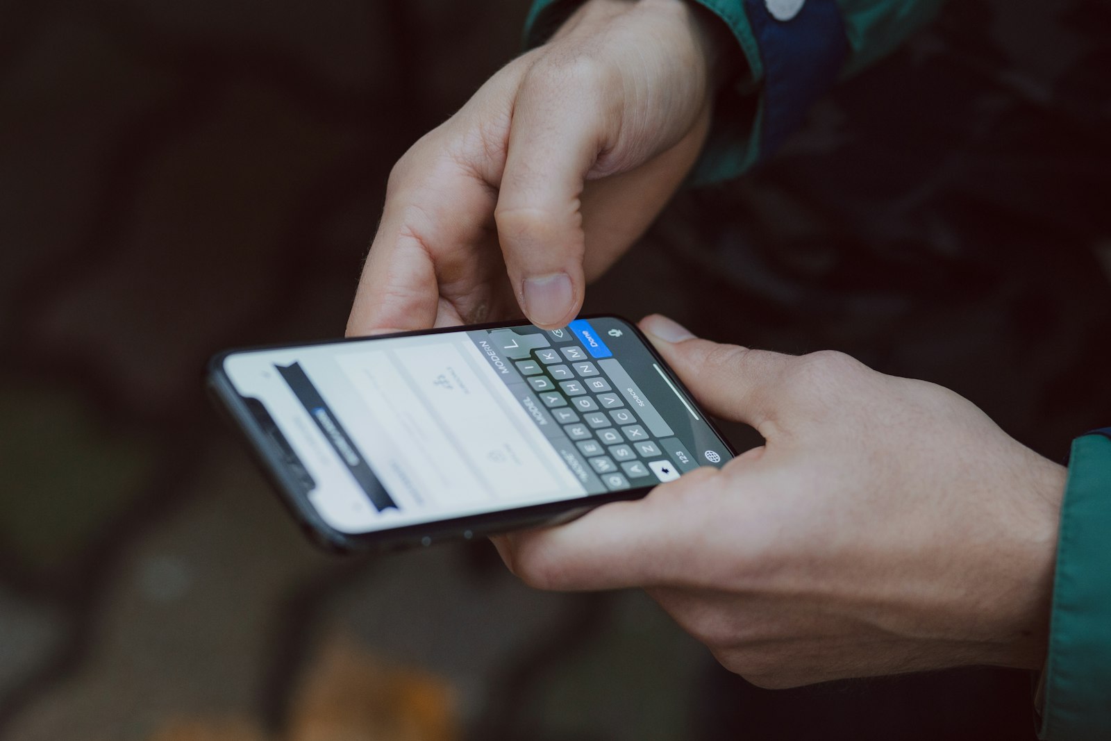 Person typing a message on a smartphone outdoors