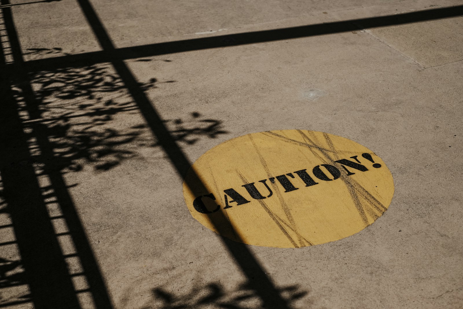 Yellow caution sign sitting beside a city road