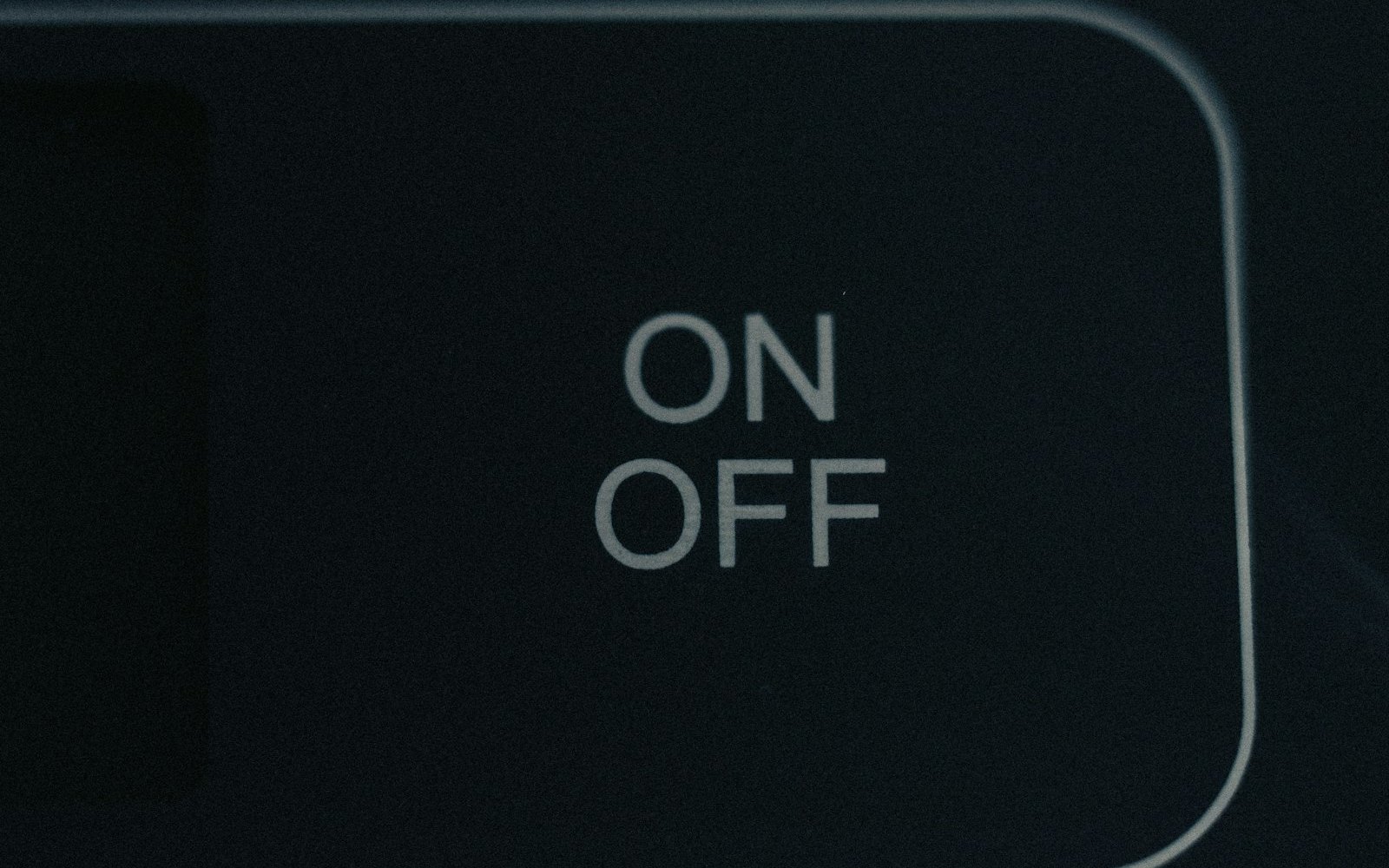 Backlit ON OFF label on a dark control panel