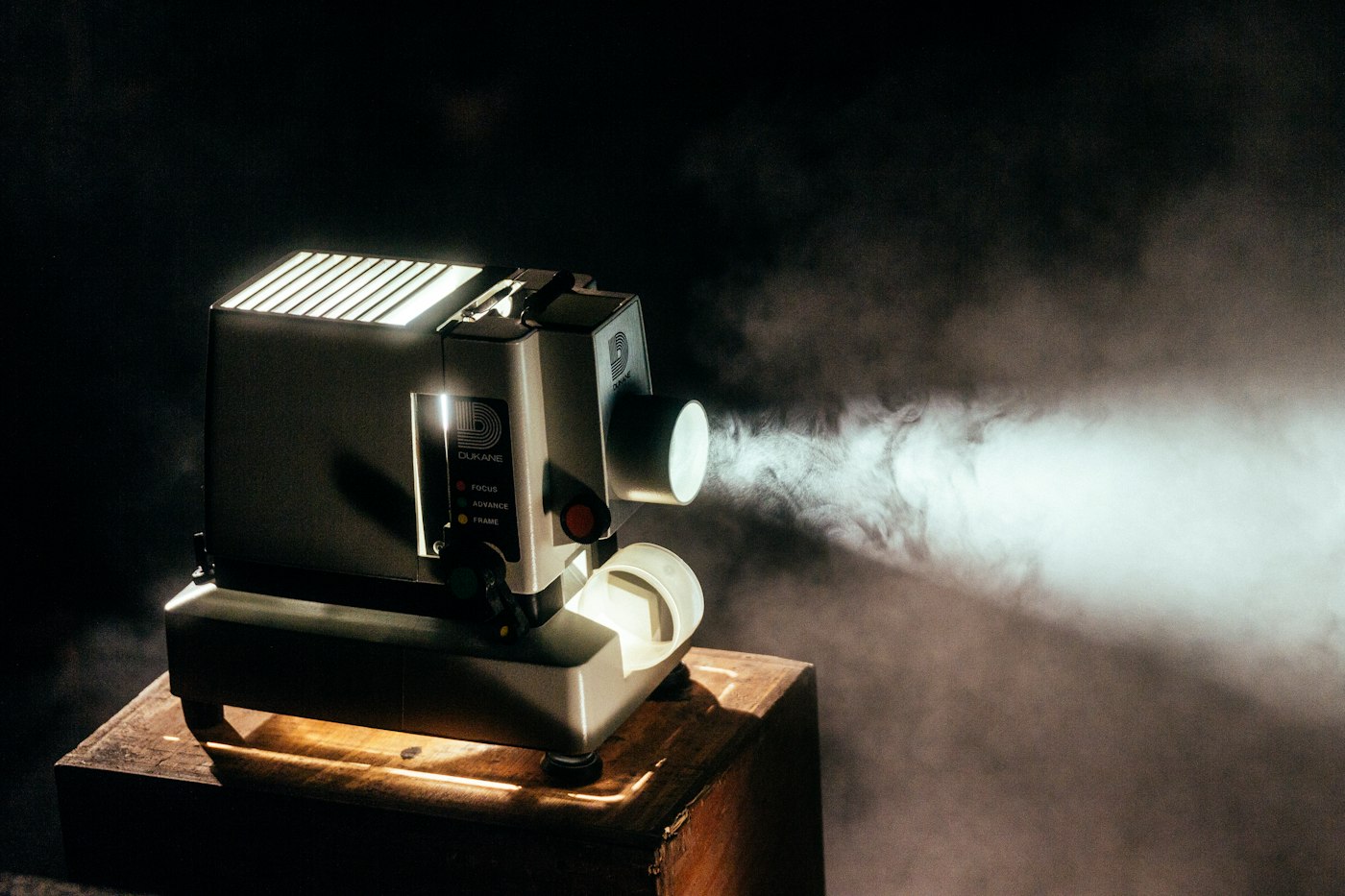 Vintage film projector casting a beam of light in a dark room