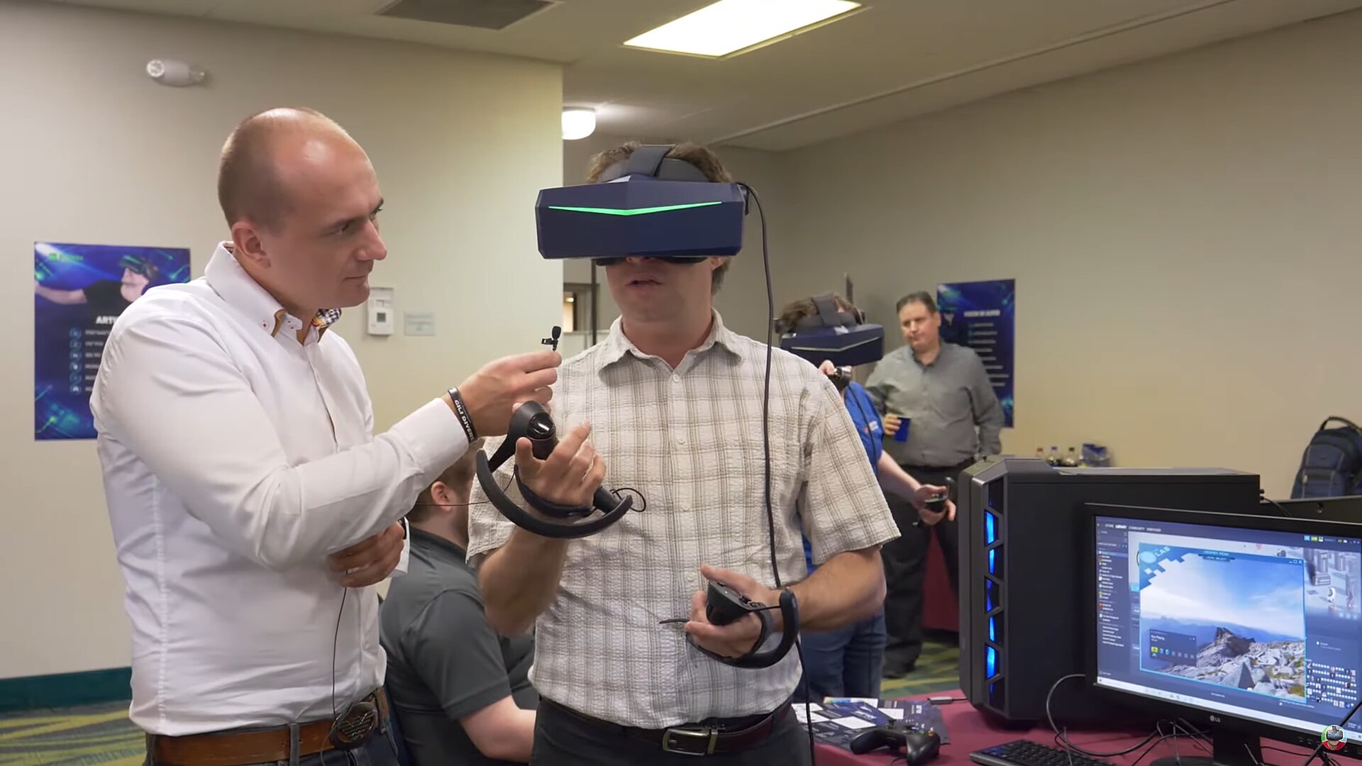 A man tries on a Pimax VR headset with controllers while a Pimax staffer guides him at a 2020 demo event