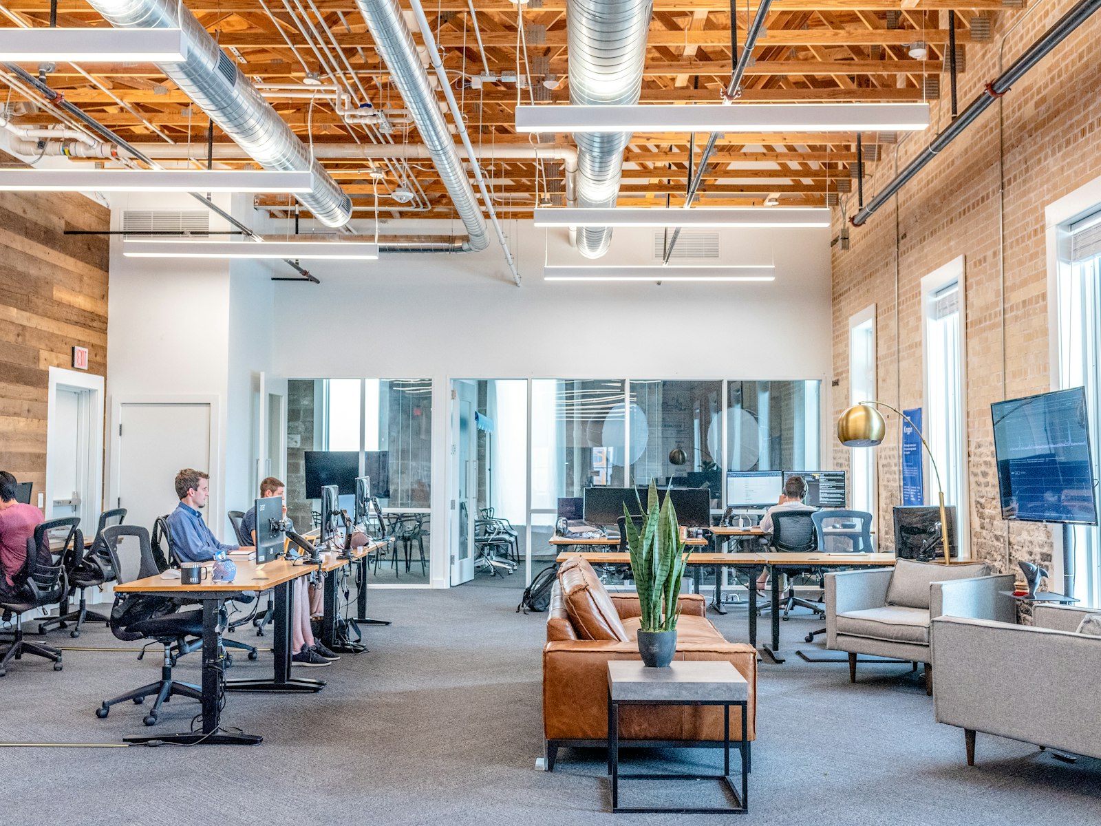 Open-plan tech office with desks, monitors, and a lounge seating area