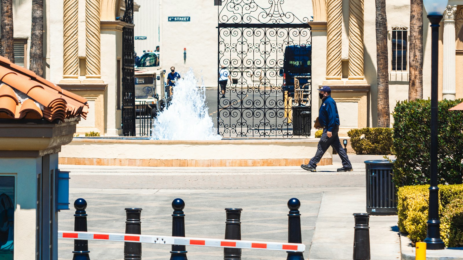 A man walks past the fountain and wrought-iron gate at the Paramount Pictures studio entrance