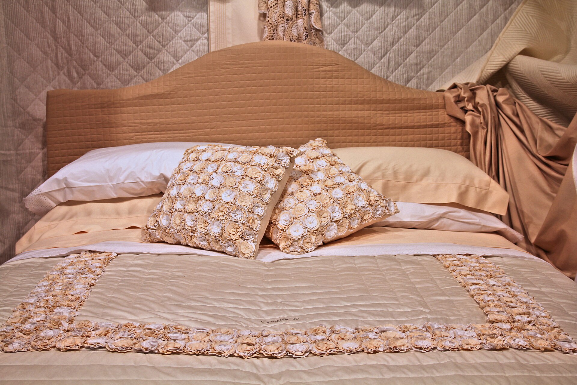 Neatly made bed with pillows and a quilted bedspread