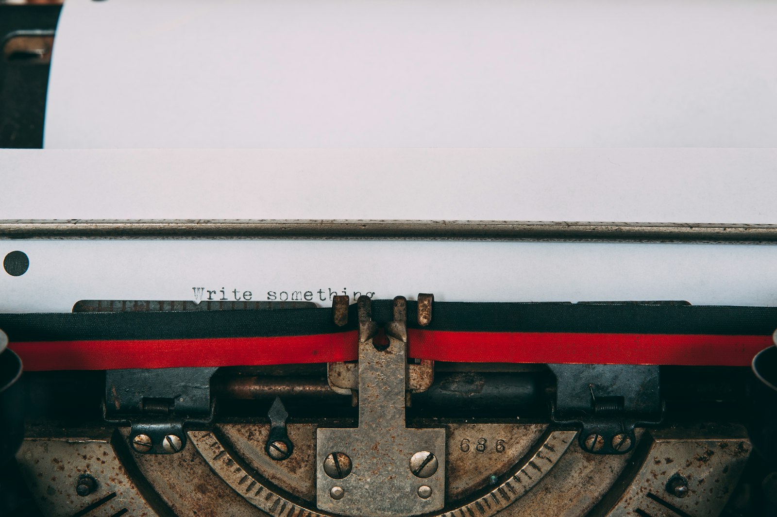 Close-up of a vintage typewriter with the words Write something typed on the paper